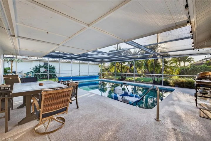 Swimming pool featuring a lanai, a patio area, a sunroom, and outdoor dining space