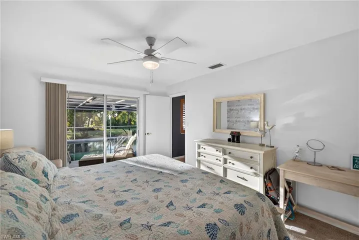 Carpeted bedroom with access to exterior and ceiling fan