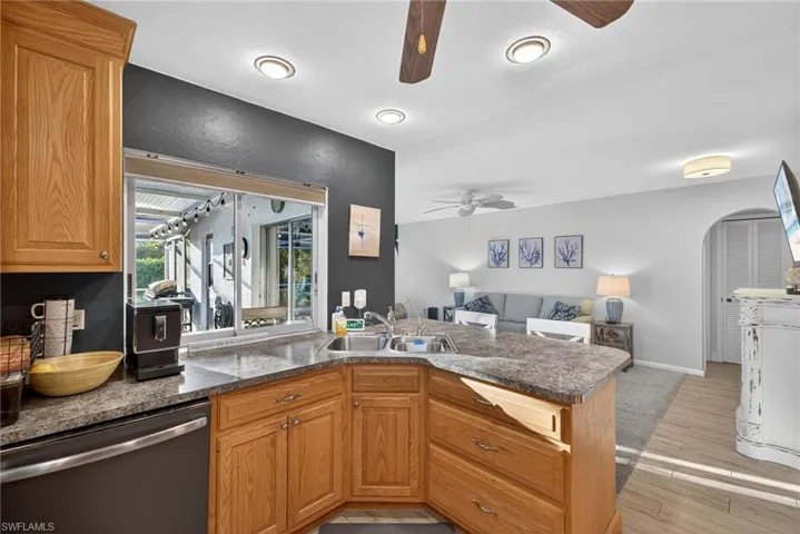Kitchen with dishwasher, open floor plan, a peninsula, and brown cabinetry