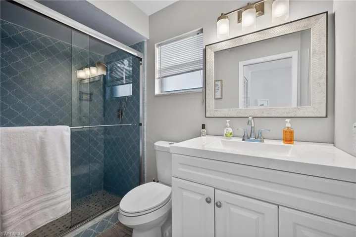 Full bathroom with vanity and a shower stall