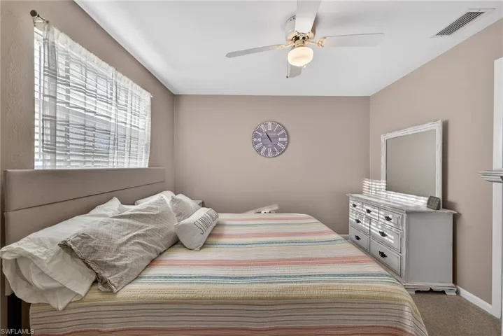 Carpeted bedroom featuring a ceiling fan and baseboards