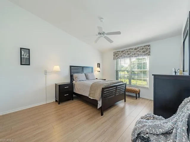 Bedroom featuring ceiling fan, light hardwood / wood-style floors, and lofted ceiling