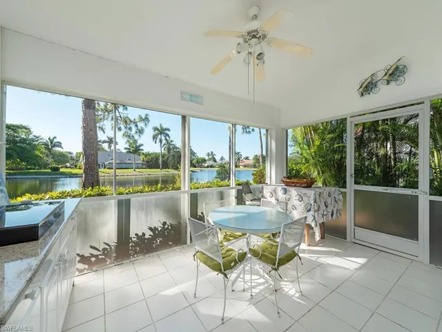 Unfurnished sunroom featuring ceiling fan, a water view, and vaulted ceiling