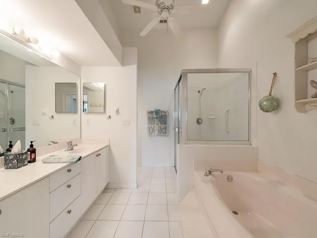 Bathroom featuring tile patterned floors, vanity, ceiling fan, and independent shower and bath