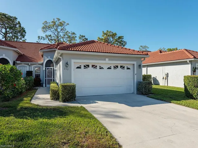 Mediterranean / spanish home with a garage and a front lawn