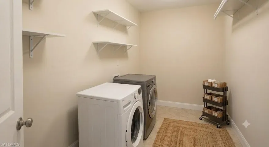 Virtually Staged Dedicated laundry area featuring white wall shelving, light-toned wall paint, and tiled flooring