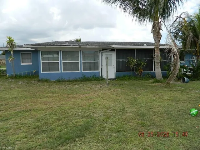 Blue exterior with multiple windows and an enclosed patio area
