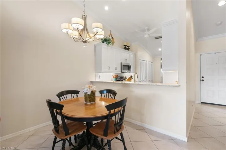 Dining room with a chandelier, light tile patterned floors, a ceiling fan, crown molding, and recessed lighting