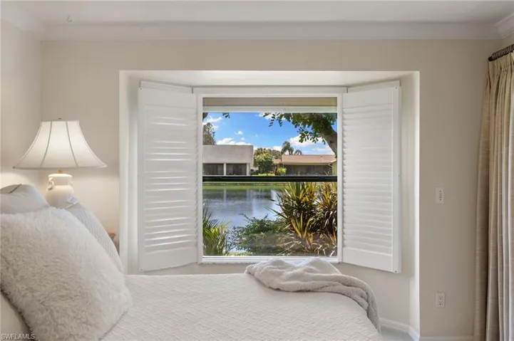 Bedroom with ornamental molding and a water view