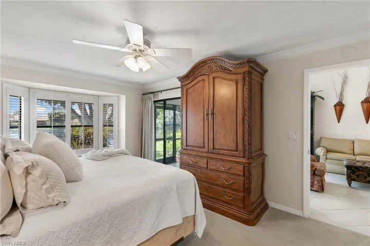 Bedroom featuring ornamental molding, light carpet, and a ceiling fan