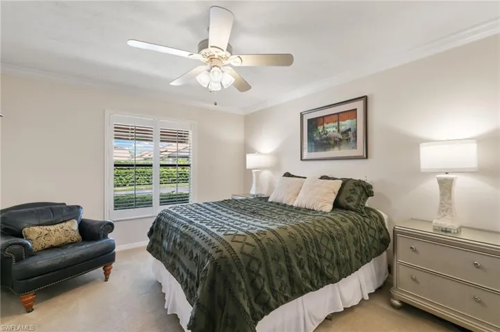 Bedroom featuring ornamental molding, light carpet, and a ceiling fan