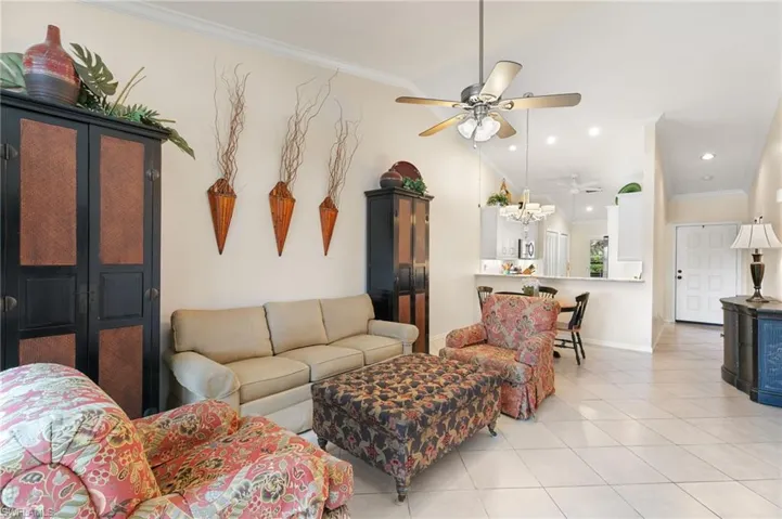 Living room featuring crown molding, light tile patterned floors, recessed lighting, and a ceiling fan