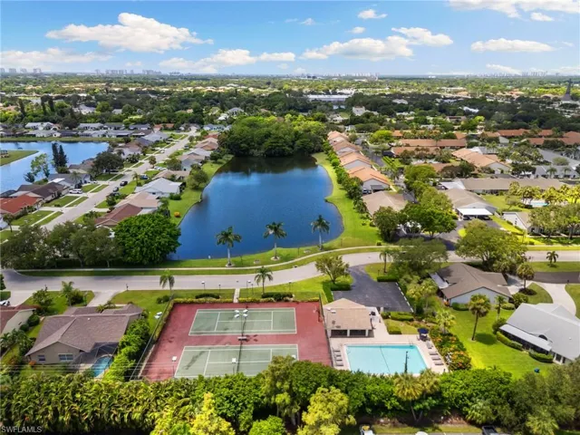 Aerial perspective of suburban area with a large body of water and a pool