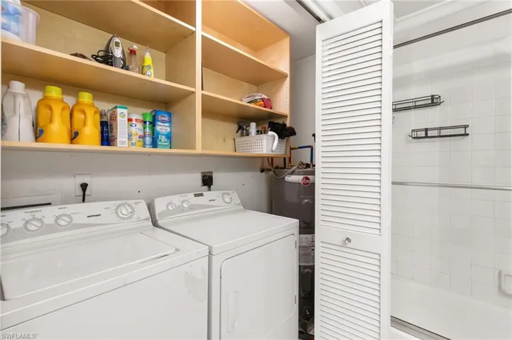 Laundry room featuring water heater and washing machine and dryer