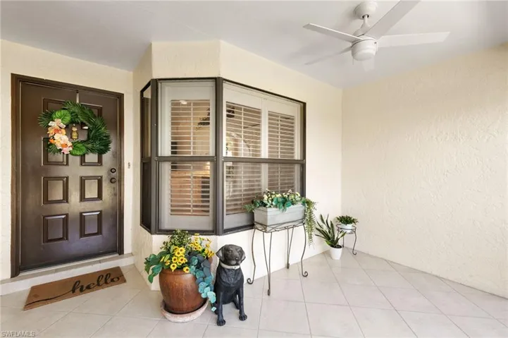 Property entrance featuring stucco siding, ceiling fan, and a sunroom