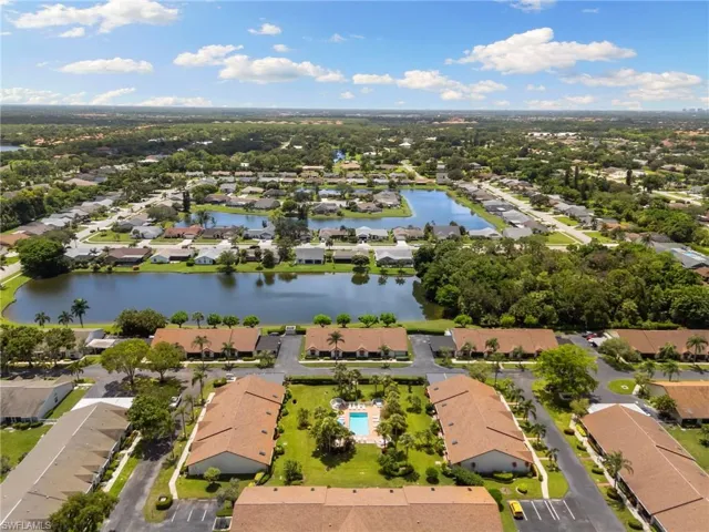 Aerial view of property and surrounding area with nearby suburban area and a large body of water