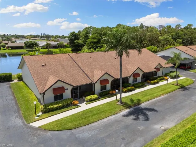 View of front of house featuring stucco siding, a shingled roof, a residential view, and a front lawn