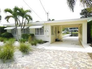 View of front of property with driveway and a carport