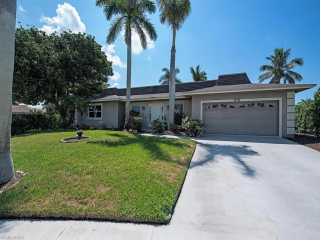 Single story home featuring a garage and a front lawn