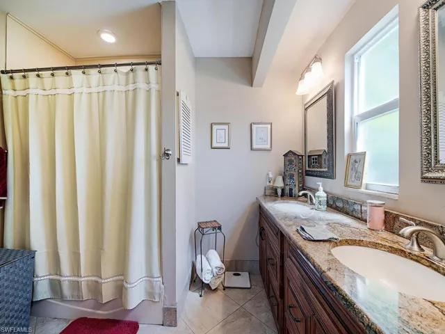 Bathroom with double vanity and tile floors