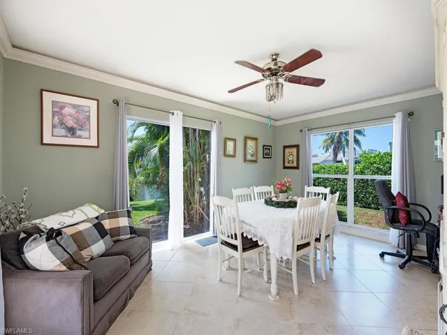 Dining space with ceiling fan, ornamental molding, and light tile flooring
