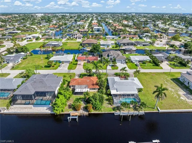 Aerial perspective of suburban area featuring a nearby body of water
