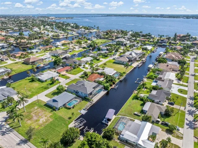 Aerial view of property and surrounding area with a large body of water and nearby suburban area