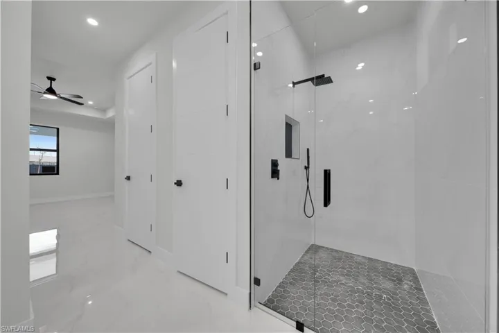 Bathroom featuring recessed lighting, a marble finish shower, ceiling fan, and marble finish floors