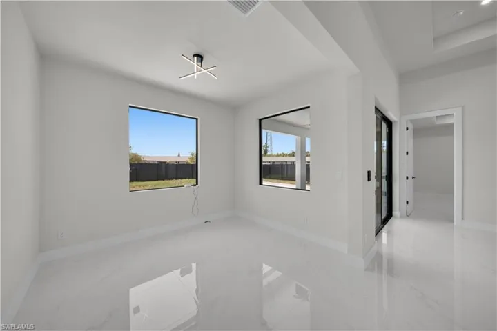Spare room featuring baseboards and light marble finish flooring