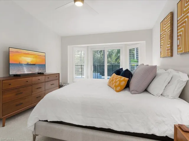 Bedroom with access to exterior, light colored carpet, and ceiling fan