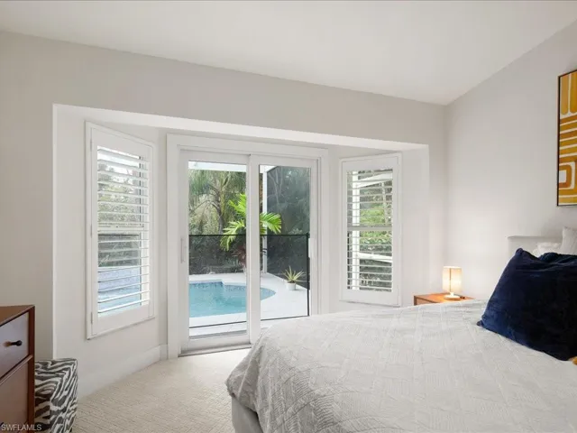 Carpeted bedroom featuring multiple windows and access to exterior
