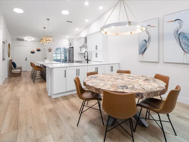 Dining area with light hardwood / wood-style floors and lofted ceiling