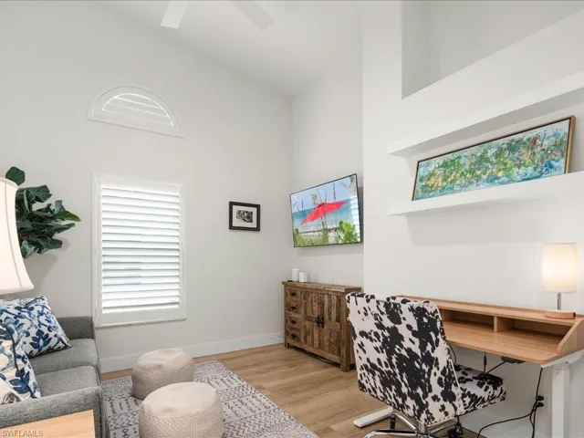 Office space featuring ceiling fan, high vaulted ceiling, and light wood-type flooring