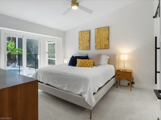 Bedroom with access to exterior, ceiling fan, light carpet, and lofted ceiling