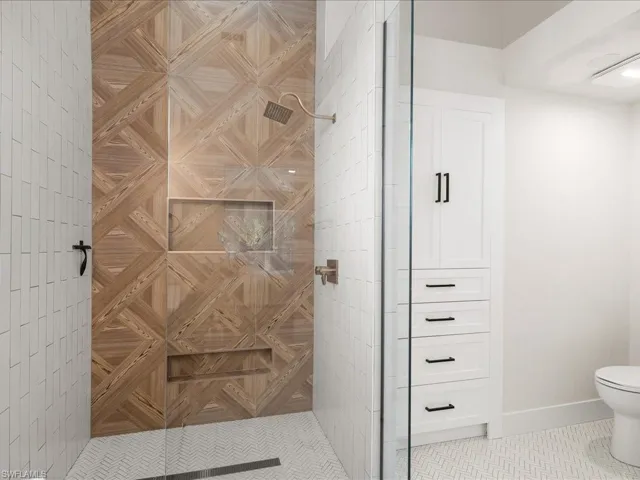 Bathroom featuring tile patterned flooring, toilet, and a shower