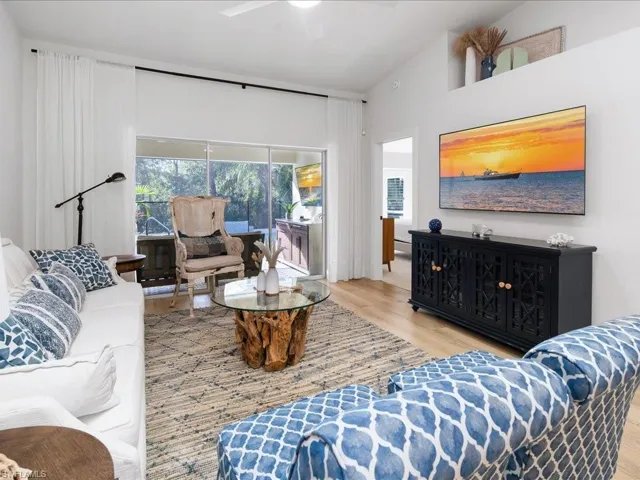 Living room featuring high vaulted ceiling, light hardwood / wood-style flooring, and ceiling fan