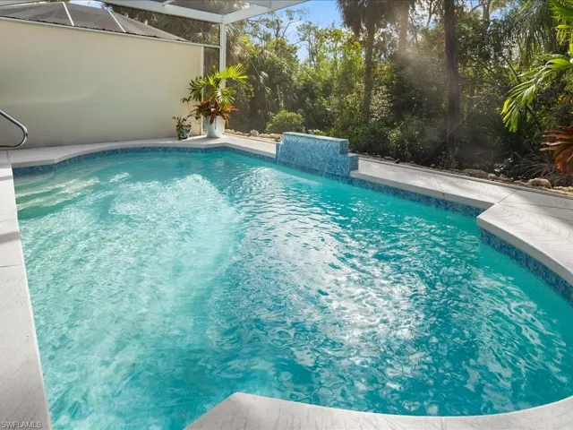 View of swimming pool featuring a lanai