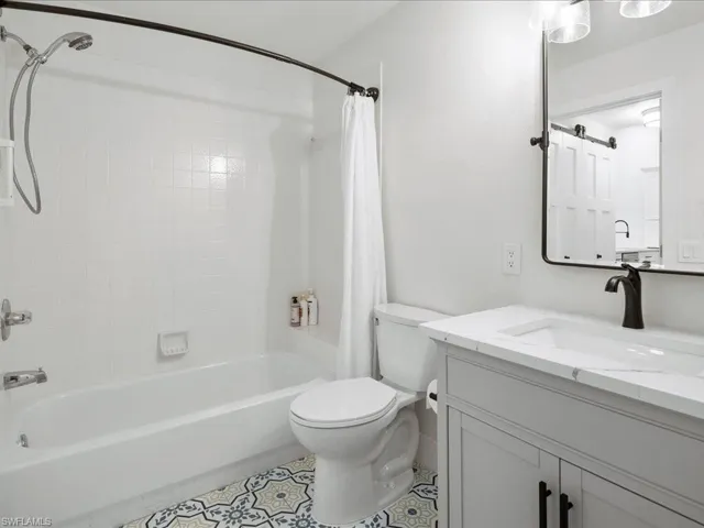 Full bathroom featuring shower / bathtub combination with curtain, vanity, and toilet