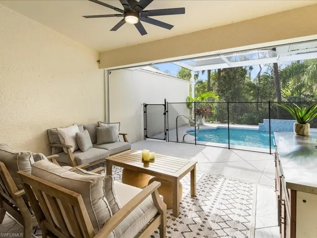 View of patio / terrace with an outdoor living space, ceiling fan, and a lanai