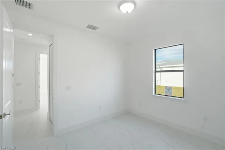 Spare room featuring baseboards and light marble finish flooring