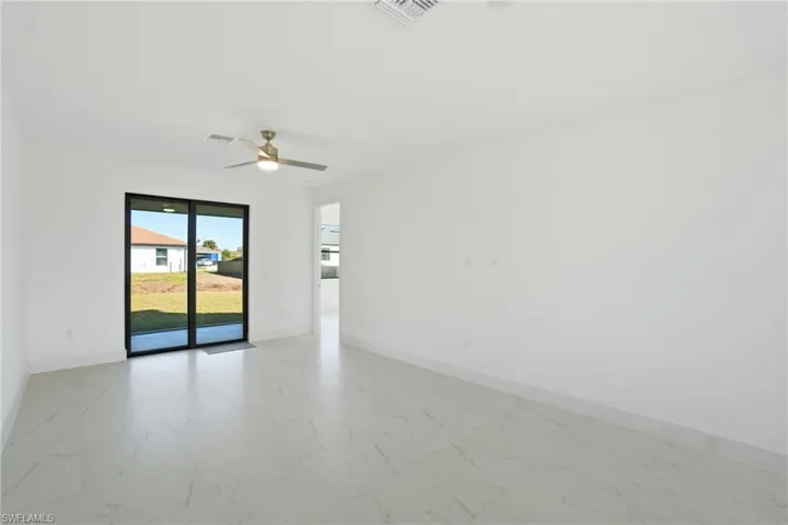 Spare room with light marble finish flooring and ceiling fan