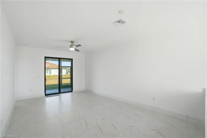 Spare room featuring light marble finish flooring and a ceiling fan