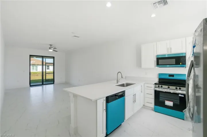 Kitchen featuring stainless steel appliances, light marble finish flooring, a peninsula, open floor plan, and recessed lighting