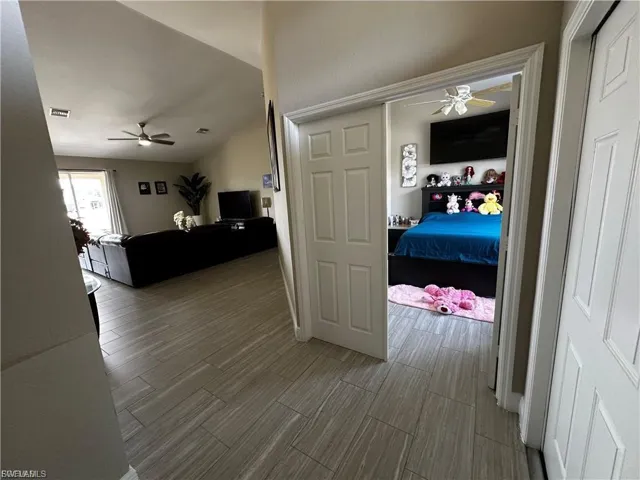 Hallway with wood tiled floors and vaulted ceiling