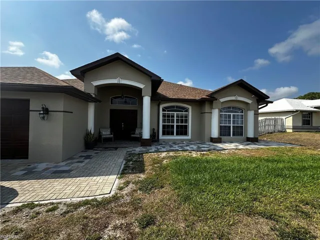 View of front of property with stucco siding, roof with shingles, and a garage