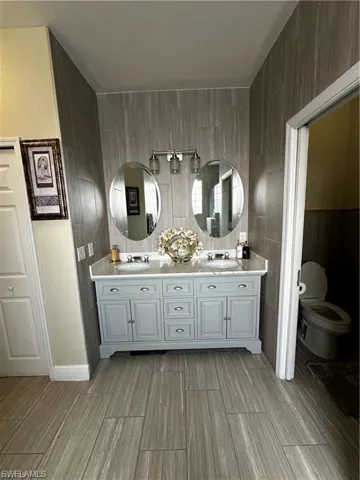Bathroom featuring double vanity and wood finish floors