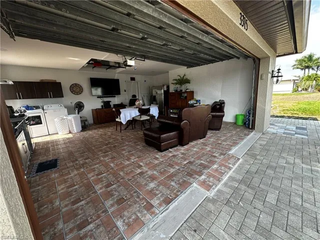 Garage with washing machine and clothes dryer and stainless steel fridge