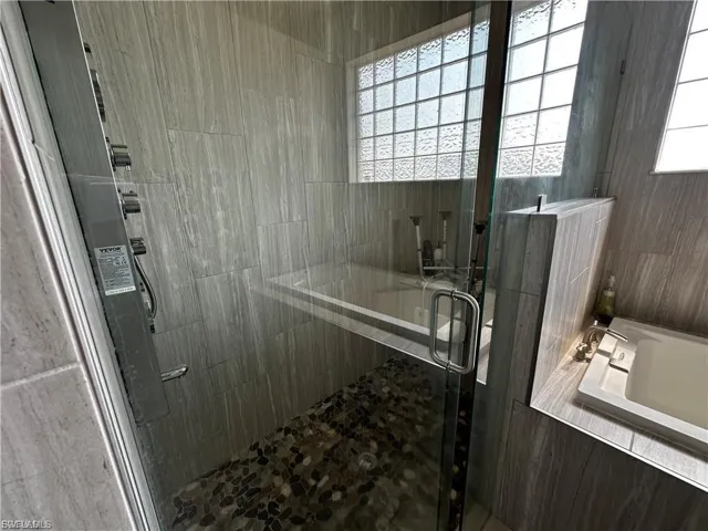 Bathroom with a bath and a stall shower