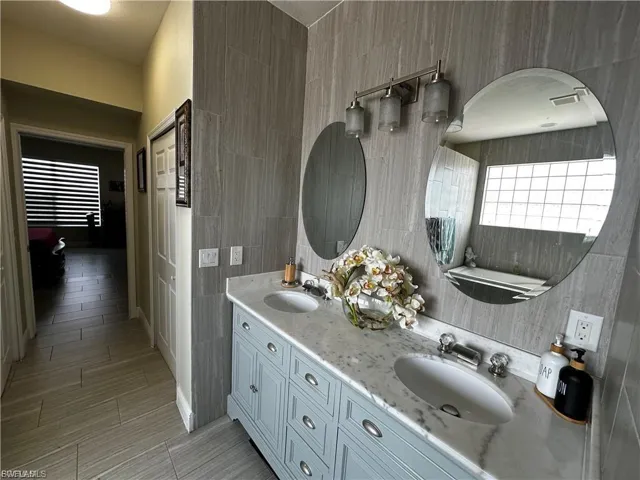Full bath with double vanity and tile walls