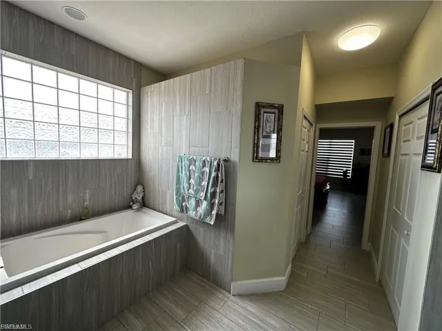 Full bathroom with baseboards and a garden tub